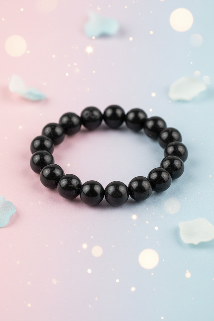 Black beaded bracelet on a pastel gradient background with crystals.