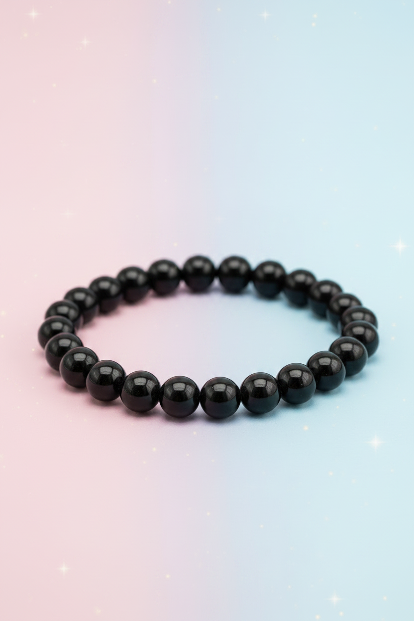 Black beaded bracelet on a gradient pink to blue background