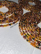 Multiple beaded necklaces in brown and black on a textured surface with 'BXC Royalties' branding.