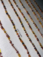 Beaded chains in brown, black, and gold on a white background
