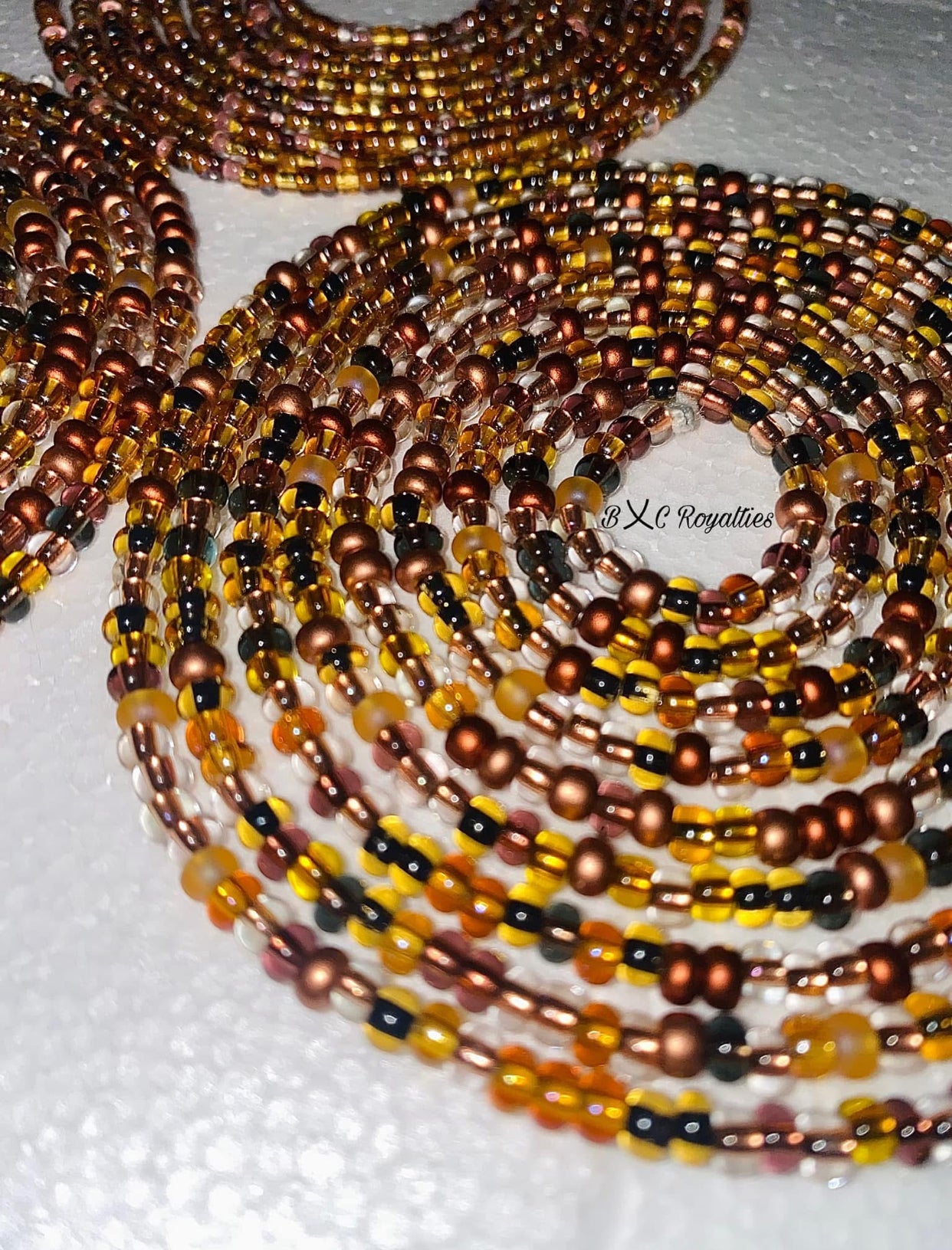 Multiple strands of multicolored beads on a white surface