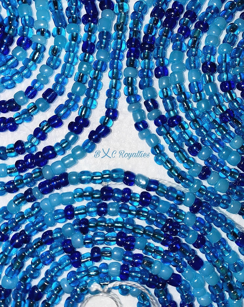 Close-up of blue beaded strands with 'BXC Royalties' branding.