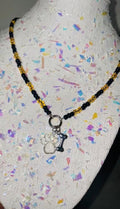 Necklace with paw and bone charm on a mannequin head with colorful background