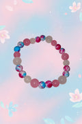 Beaded bracelet with pink, blue, and white pattern on a marble surface