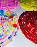 Colorful beaded necklaces with heart shapes on a white surface
