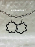 Black hoop earrings with a chain on a textured white background, featuring the brand 'BXC Royalties'.