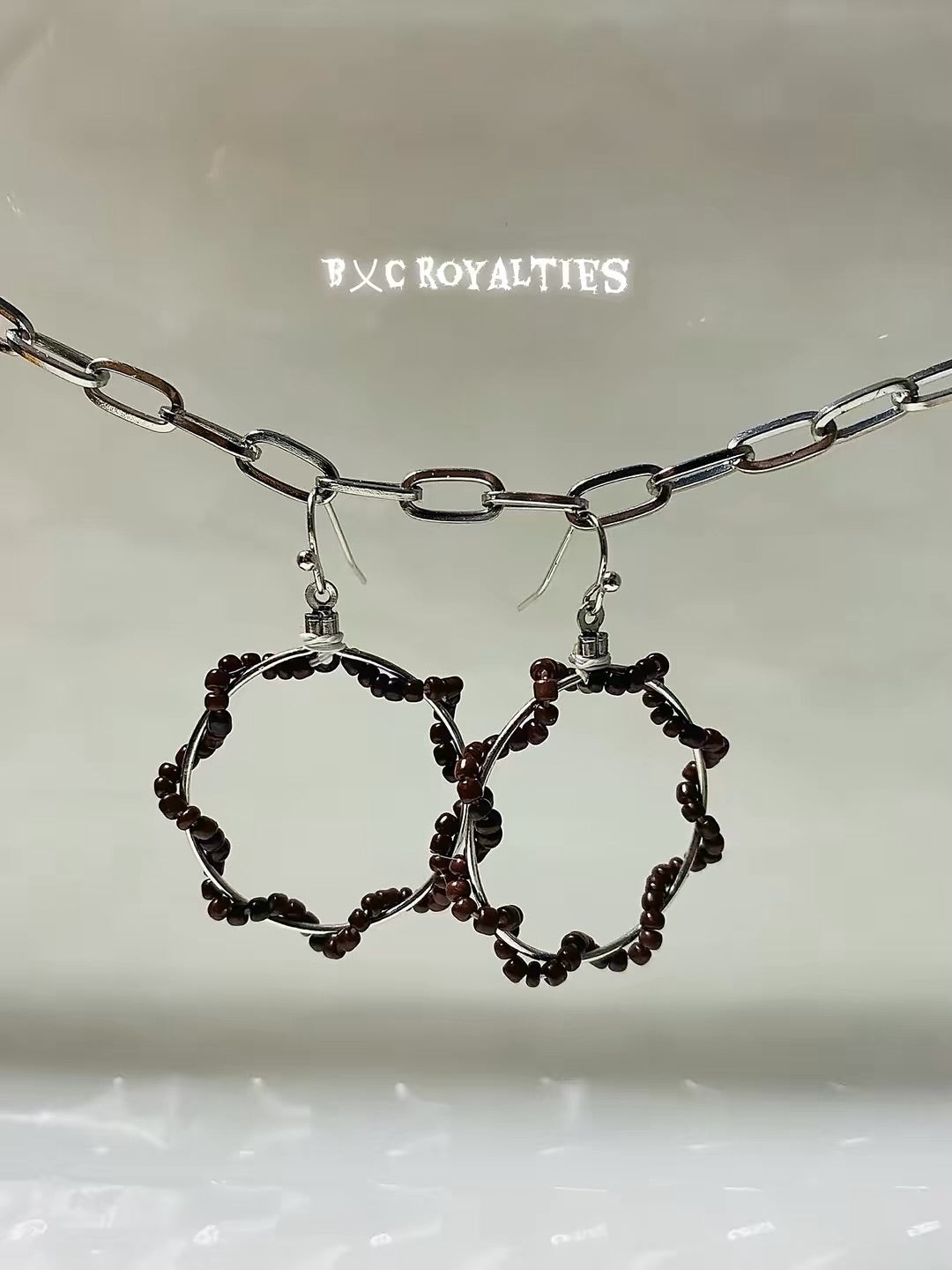 Hoop earrings with a chain on a light gray background, featuring 'BXC Royalties' branding.