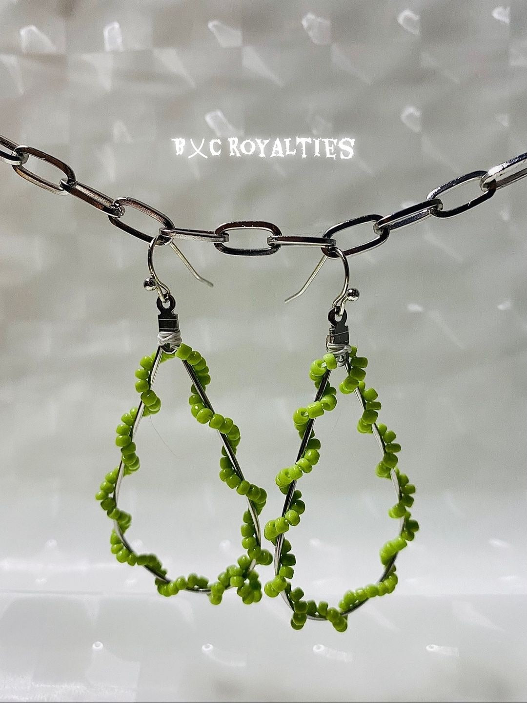Lime Green beaded hoop earrings hanging from a chain against a light background with 'BXC Royalties' branding.