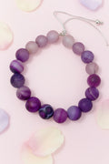 Purple beaded bracelet on a marble surface