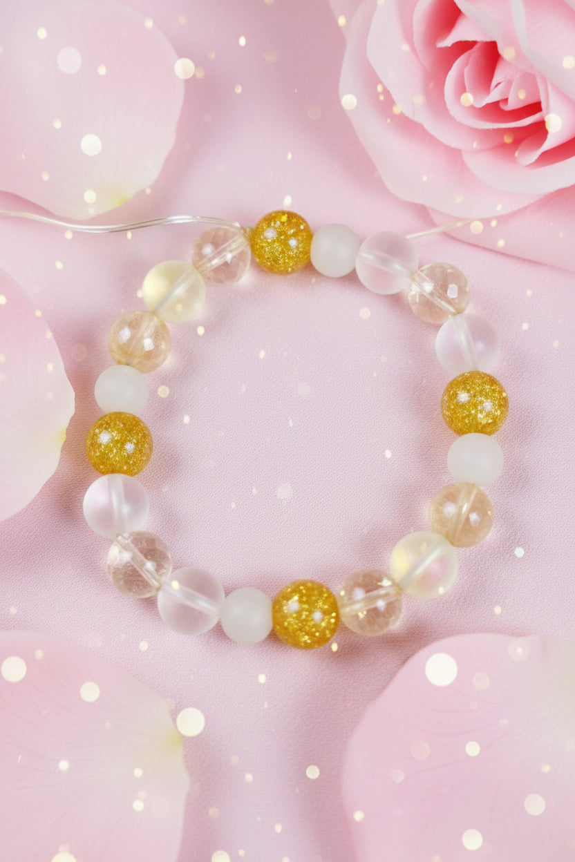 Bracelet with gold and white beads on a marble surface