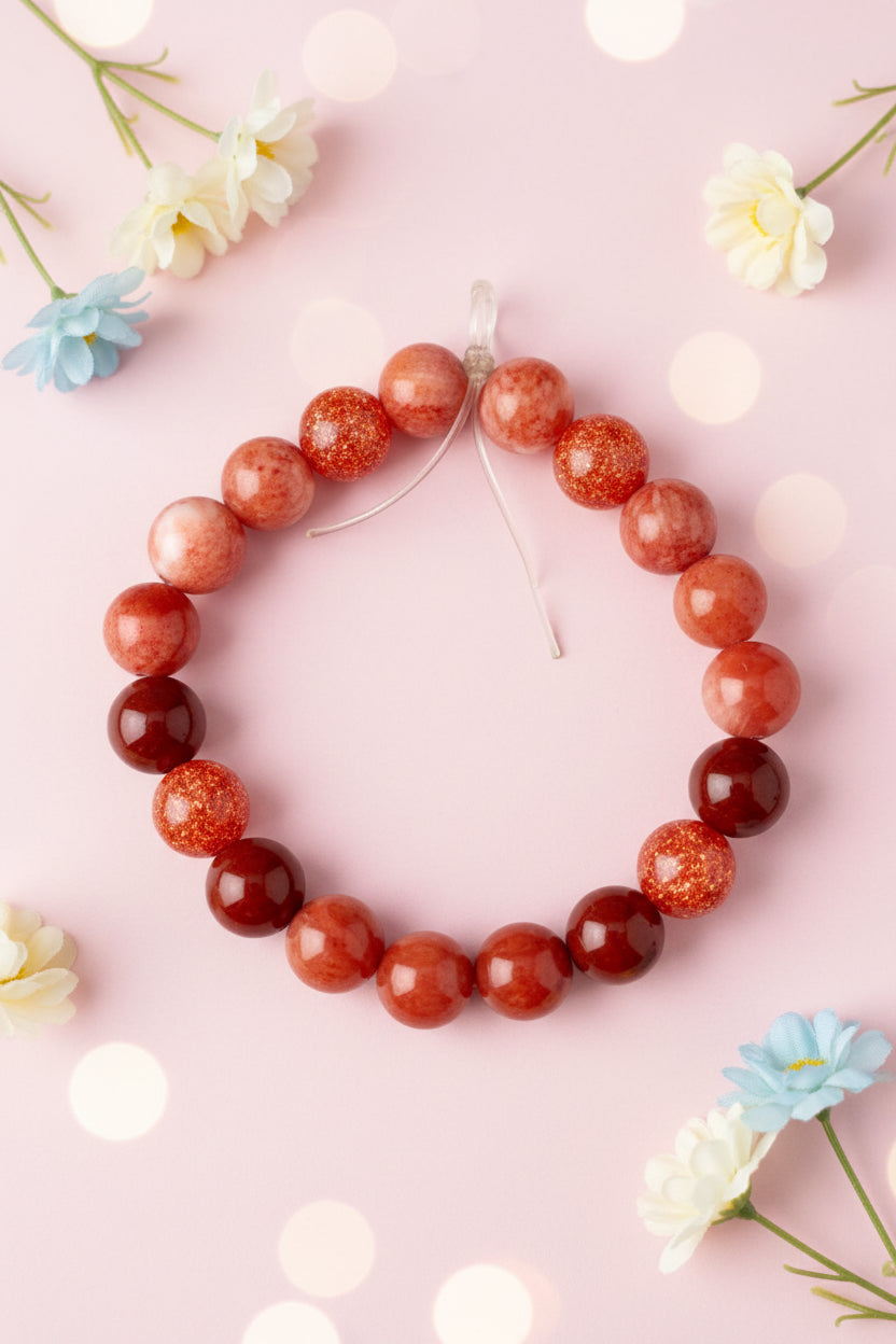 Bracelet with red and brown beads on a marble surface