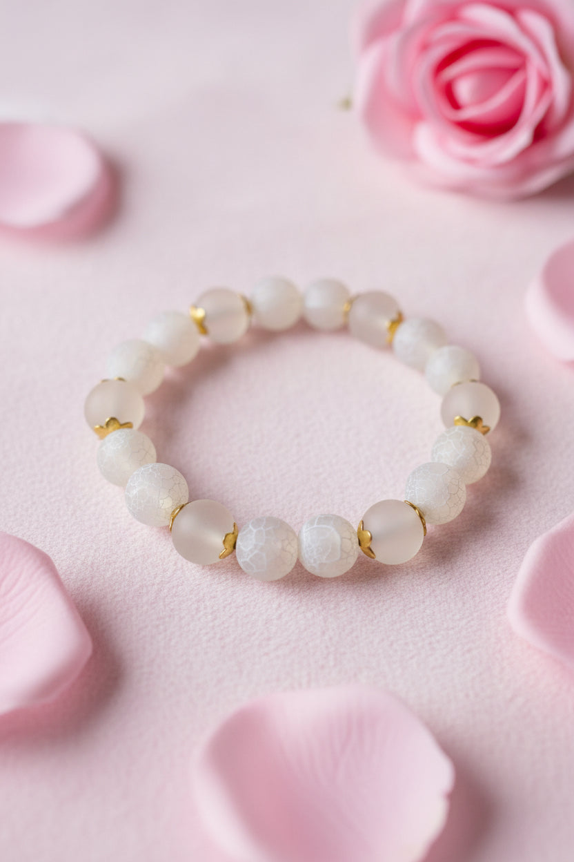 Bracelet with light-colored beads on a marble surface