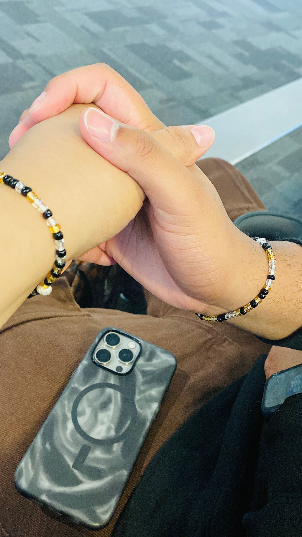 Couple holding the hands with a non-stretch beads bracelet as last forever.