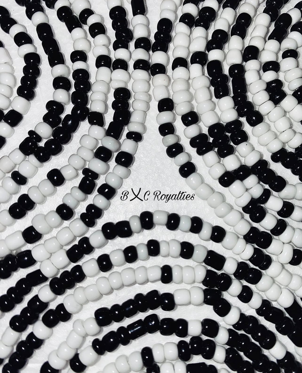Close-up of black and white beaded pattern with 'BXC Royalties' branding.