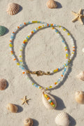 Necklace with shell pendant on a marble surface