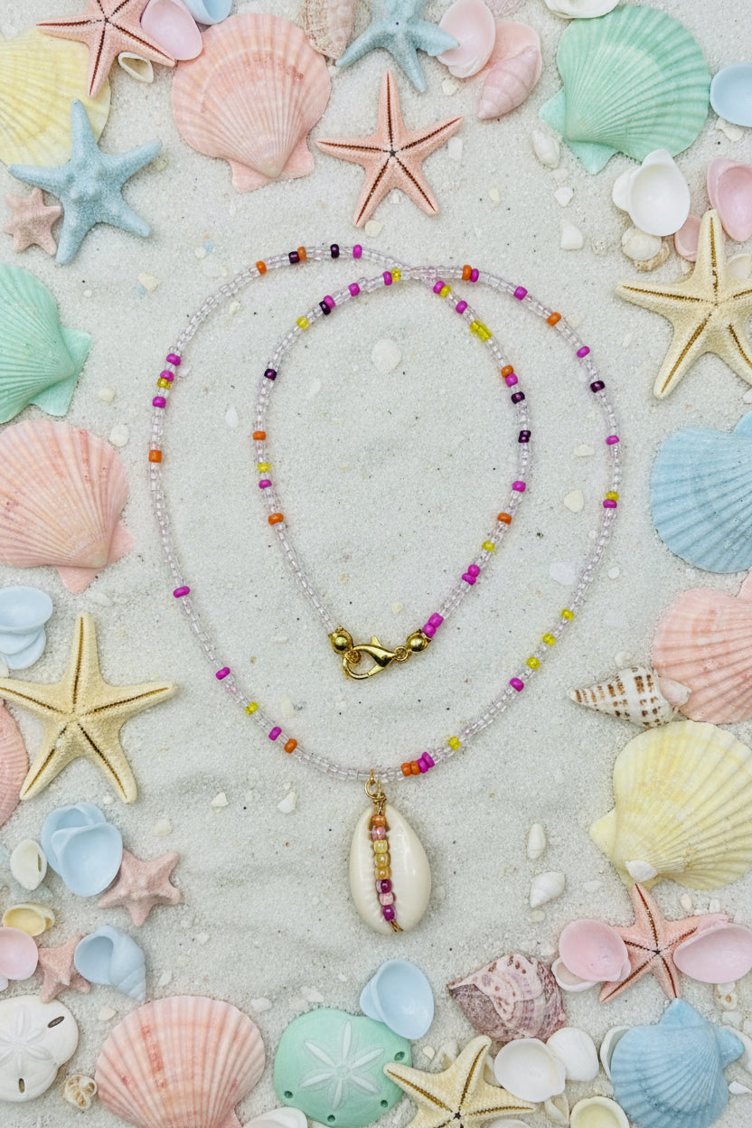 Necklace with a shell pendant on a marble surface