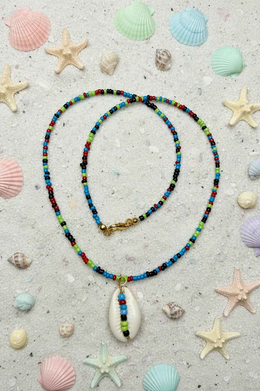 Colorful beaded necklace with a shell pendant on a marble surface