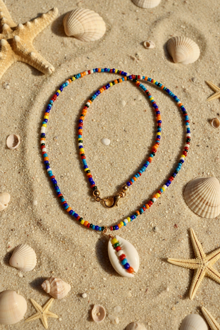 Necklace with beadwork and a shell pendant on a marble surface