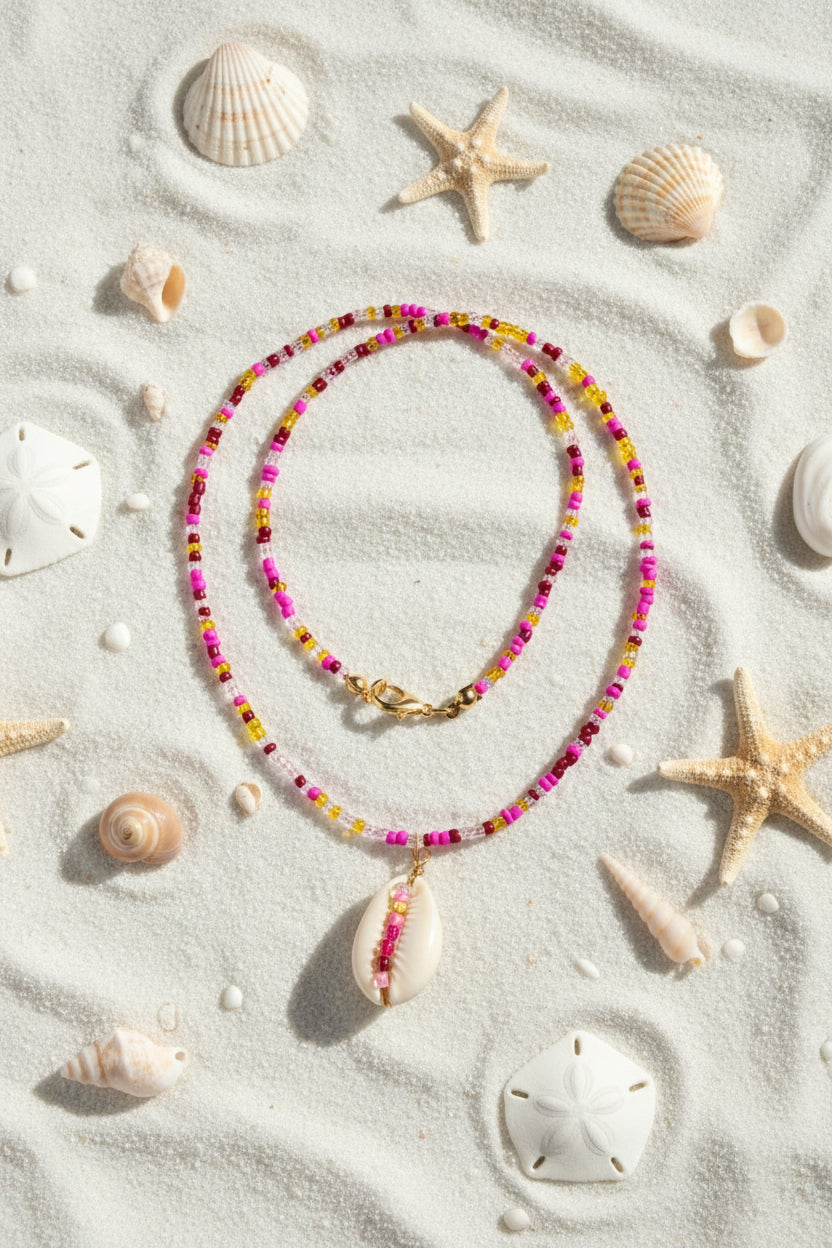 Necklace with colorful beads and a shell pendant on a marble surface