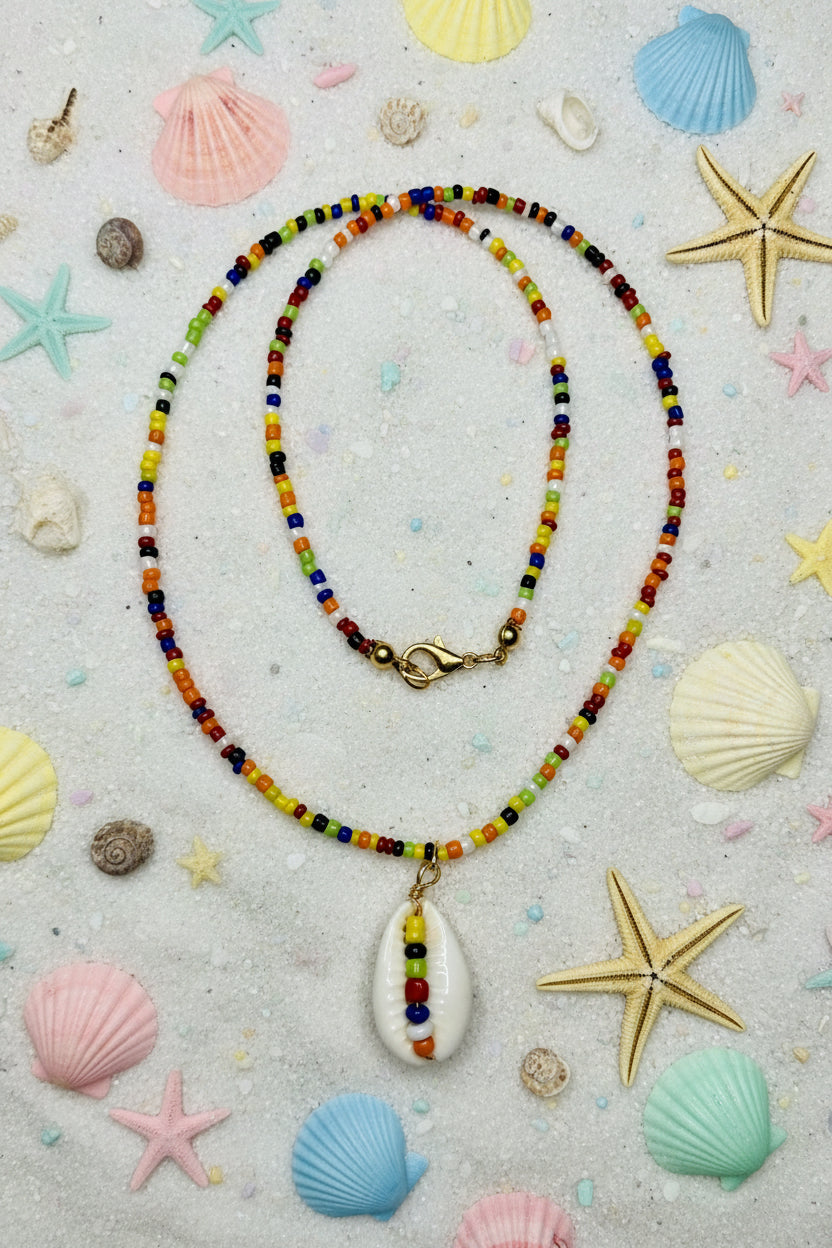 Colorful beaded necklace with a white pendant on a marble surface