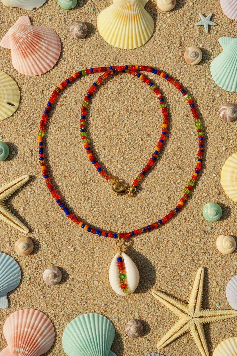 Colorful beaded necklace with a white shell pendant on a marble surface