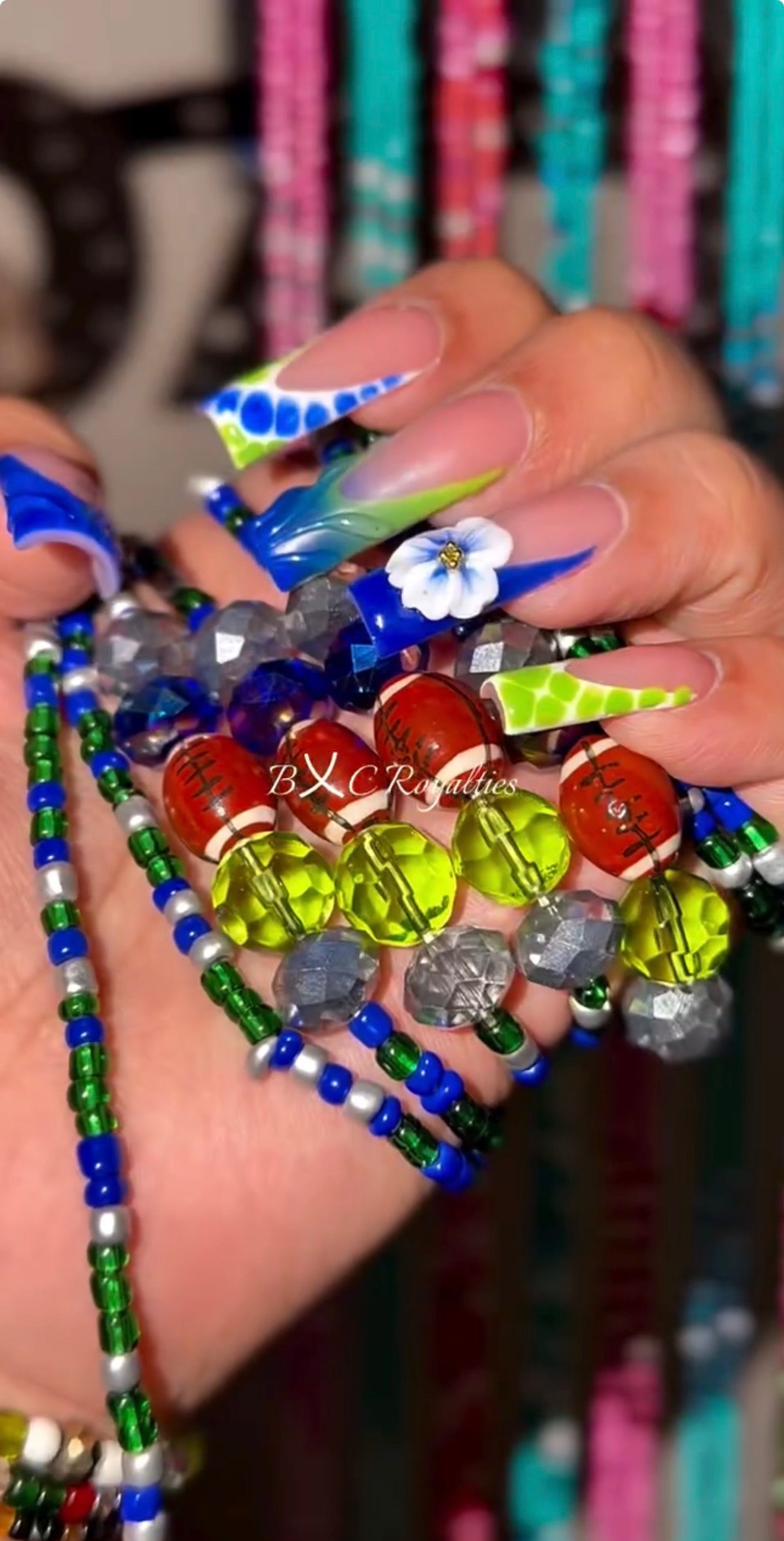 Colorful waist-beads with decorative nails held by me.