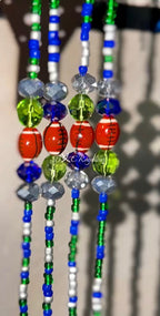 Colorful beaded strands with various beads on a blurred background