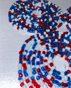 Close-up of red, white, and blue beaded pattern on a textured surface