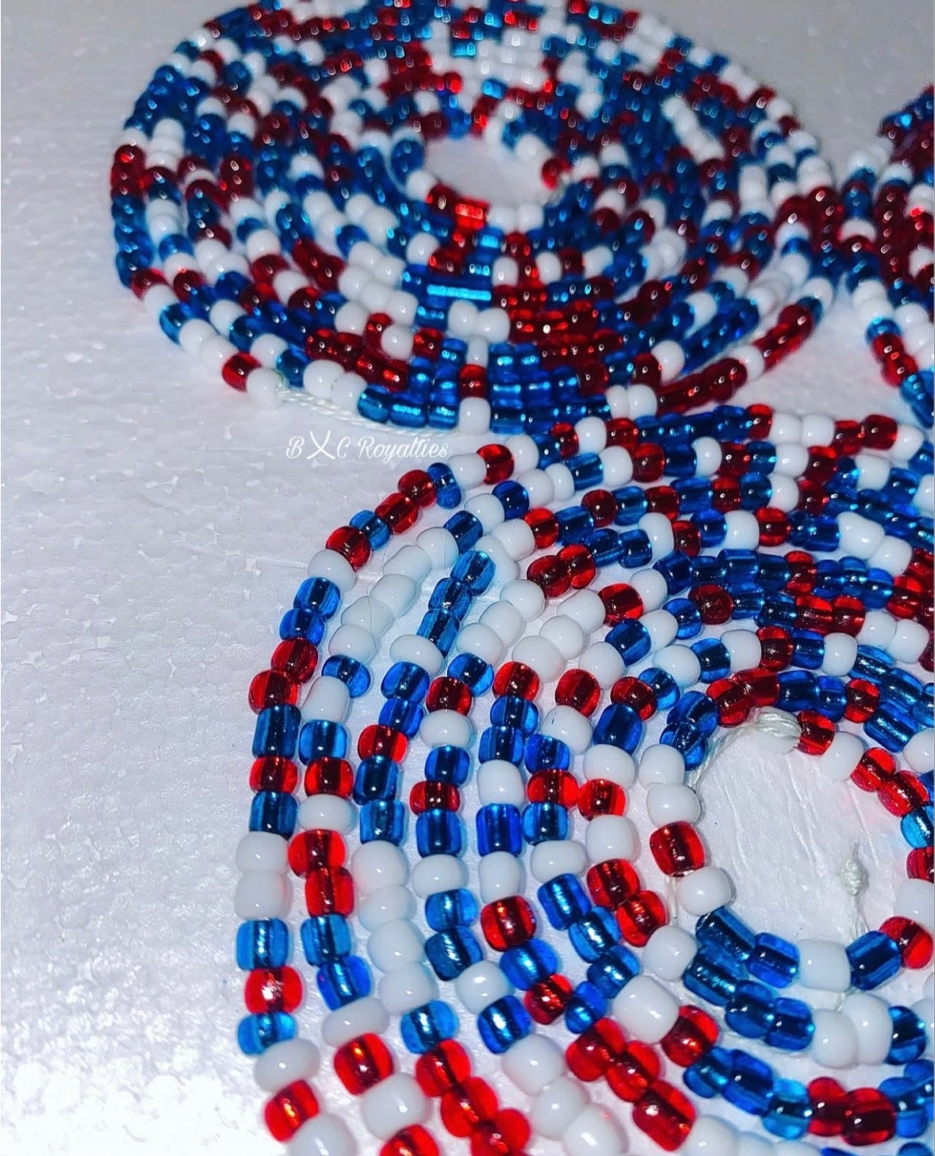 Close-up of red, white, and blue beaded pattern on a textured surface