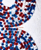 Red, white, and blue beaded necklaces on a textured white background