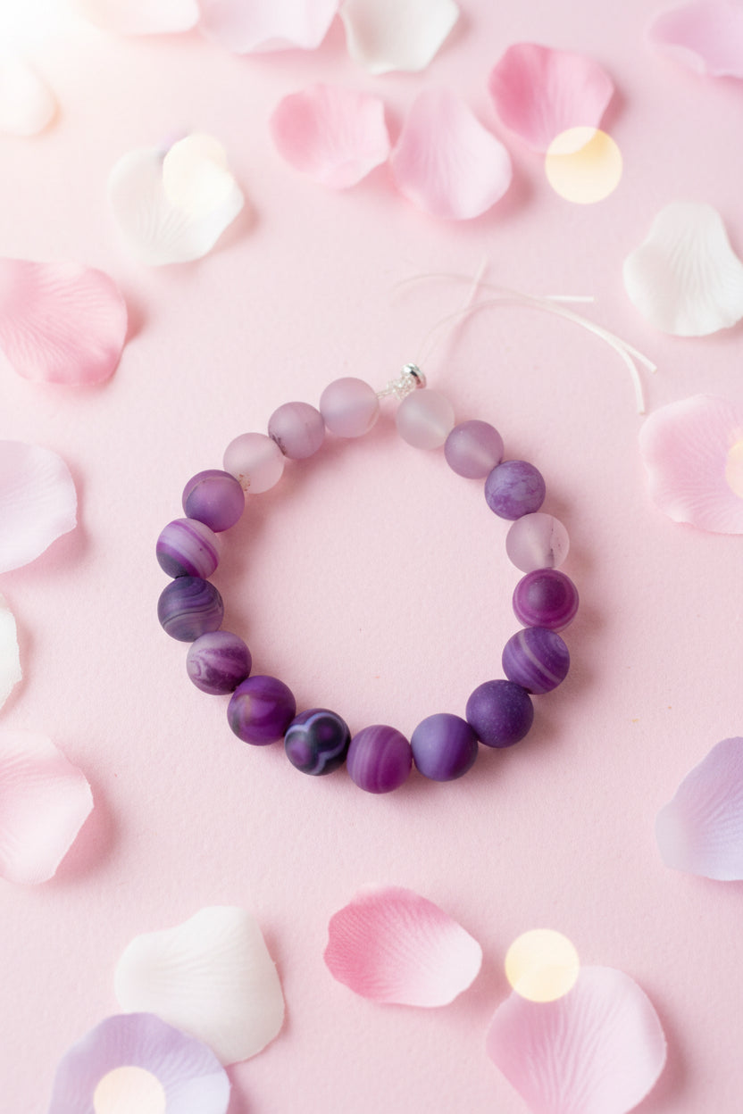 Purple beaded bracelet on a marble surface