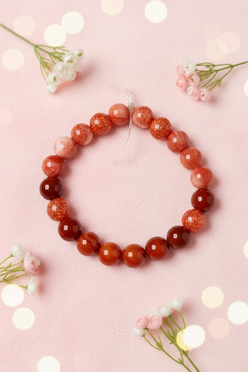 Bracelet with red and dark red beads on a marble surface