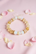 Beaded bracelet with clear yellow and white beads on a marble surface, add gold star