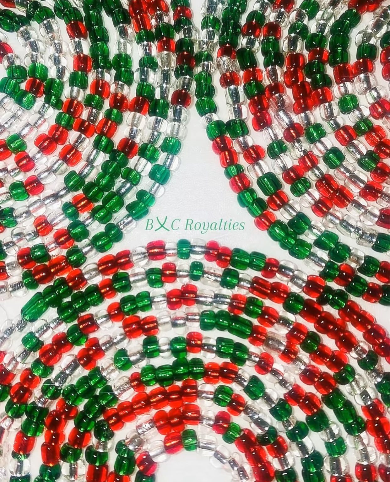 Close-up of red, green, and clear beaded string with 'BXC Royalties' branding.