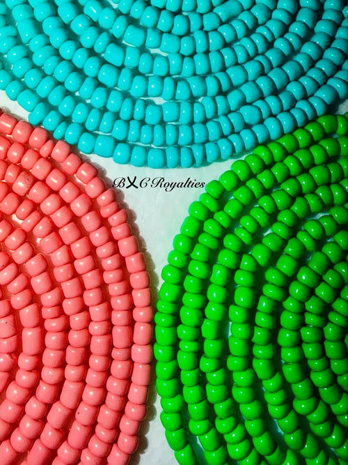 Close-up of colorful beads in turquoise, pink, and green on a white background with 'BXC Royalties' branding.