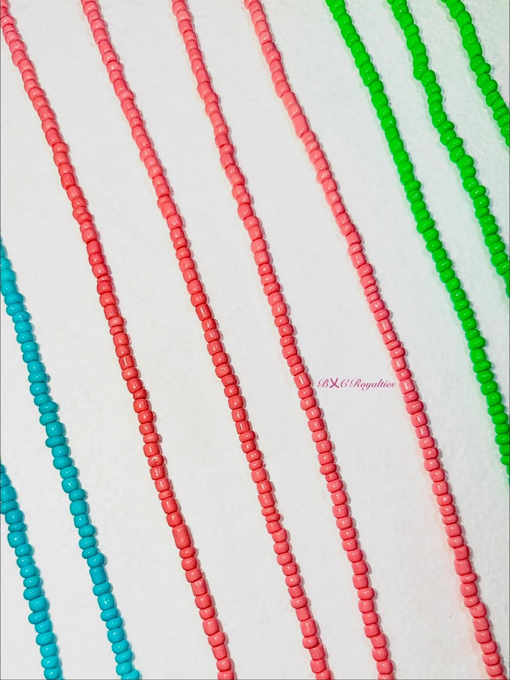 Colorful beaded strands in red, green, and blue on a white background