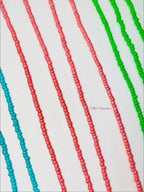Colorful beaded strands in red, green, and blue on a white background