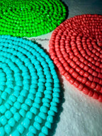 Three coiled rubber bands in green, red, and blue on a white surface.